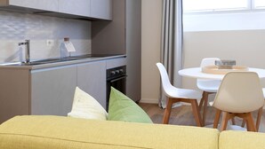 A modern kitchen with a built-in oven and a dining area with a round table and chairs.