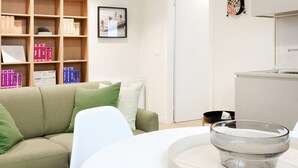 A modern living room with a sofa, a coffee table, and a bookshelf filled with books.