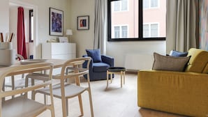 A modern living room with a dining area, featuring a sofa, chairs, a coffee table, and artwork on the walls. - Mi-brgz1c2 Bergonzoli Place - Bilo B - Blues (Milan)