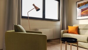 A living room with a sofa, a small table, a floor lamp, and a radiator. - Mi-brgz1c4 Bergonzoli Place - Bilo B - Canoe (Milan)