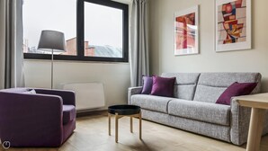 A modern living room with a grey sofa, purple cushions, a black coffee table, and a floor lamp. - Mi-brgz1c3 Bergonzoli Place - Bilo B - Hugo (Milan)