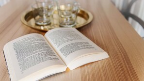 Ein offenes Buch auf einem Holztisch mit einem Tablett voller Gläser.