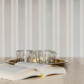 Ein Tisch mit zwei klaren Gläsern und einem Buch auf einer Ablagefläche.