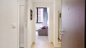A hallway leading to a bedroom with a bed, a window with curtains, and a door. - Mi-brgz1c1 Bergonzoli Place - Bilo B - Nina (Milan)