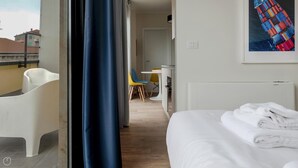 Quarto de hotel com cama, banheiro e área de jantar.