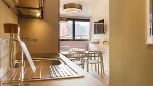 A modern kitchen with a stainless steel sink, white chairs, and a hanging light fixture. - Mi-brgz1b3 Bergonzoli Place - Trilo - Shakespeare (Milan)
