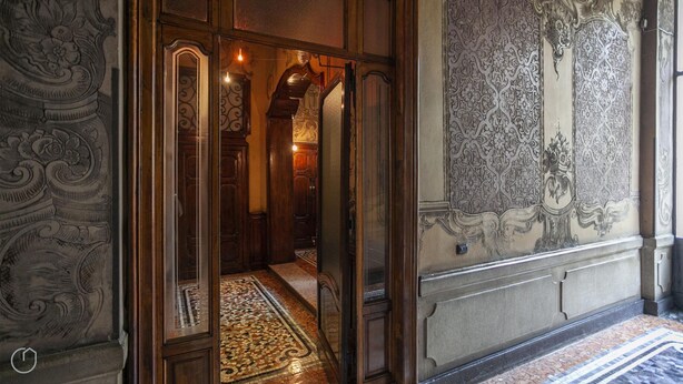 A hallway with ornate wall designs, a patterned floor, and wooden doors. - Italianway Comfort - Lombardia 96 (Milan)