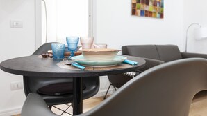 A round dining table with a blue plate, a blue glass, and a white plate with a brown rim. - Italianway Easy - Segrino 6 (Milan)