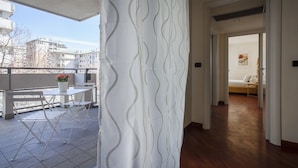 A modern apartment with a balcony, a dining area, and a bedroom. - Italianway Comfort - Spadolini 6 (Milan)