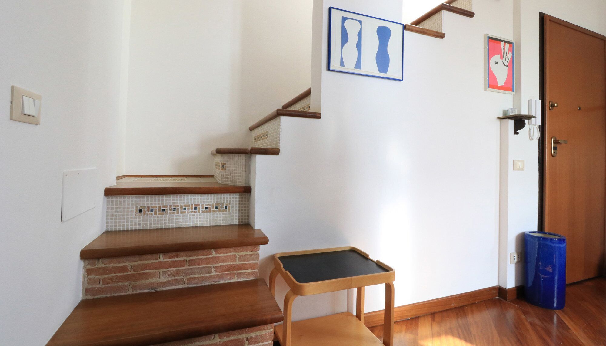 Una escalera con escalones de madera y una pequeña mesa con superficie negra.