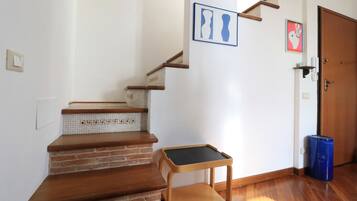 Una escalera con escalones de madera y una pequeña mesa con superficie negra.