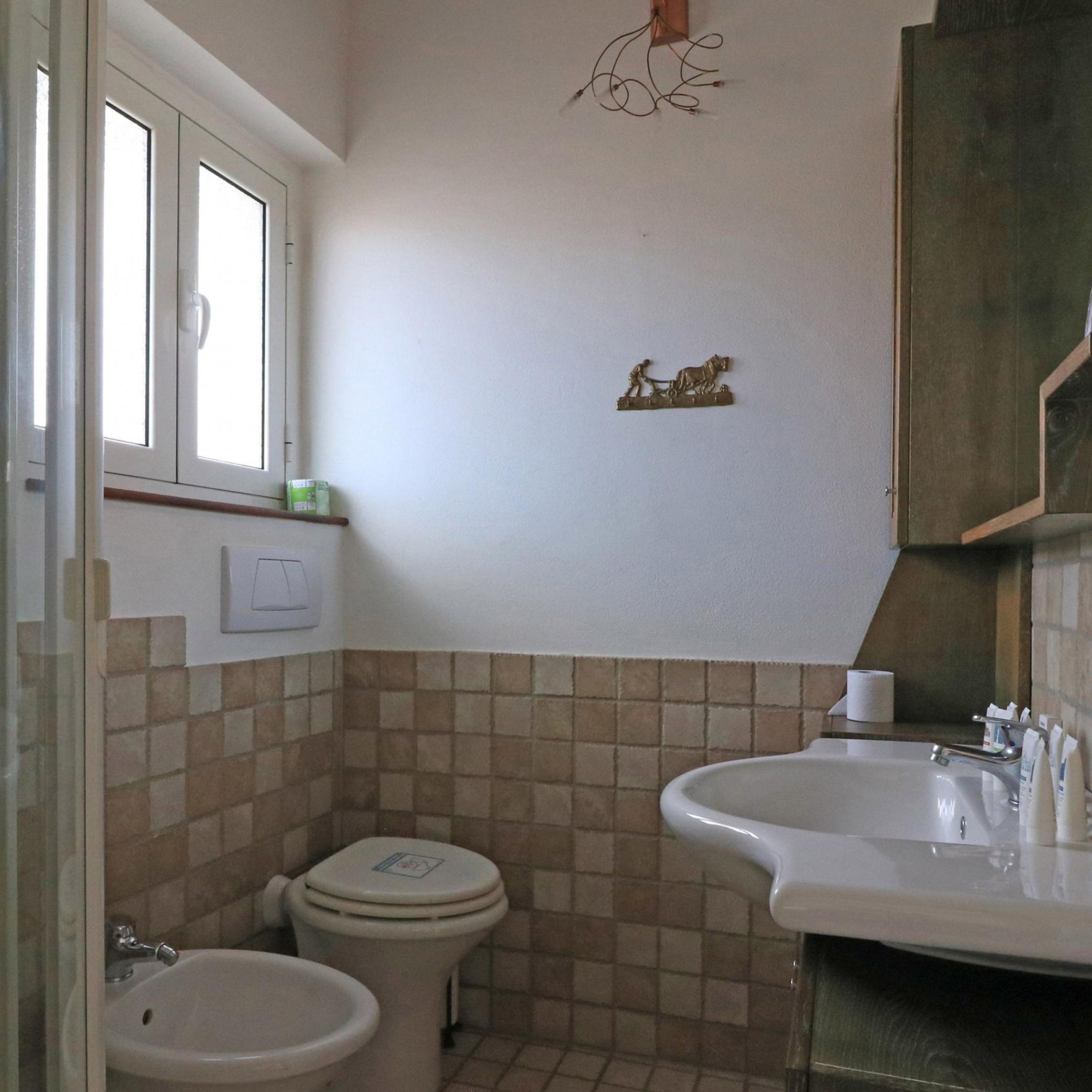 Uma casa de banho com sanita, bidé e lavatório.