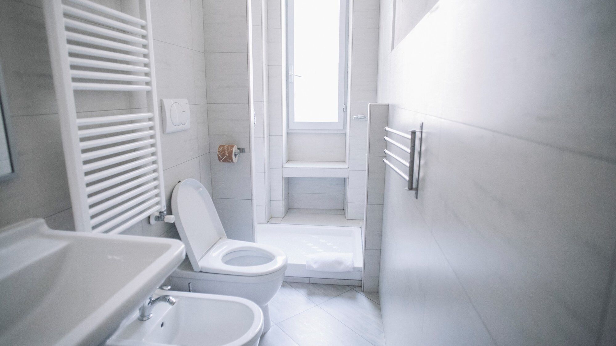 A compact bathroom with a toilet, bidet, and bathtub.