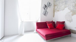A modern living room with a red sofa, white curtains, and abstract wall art. - Italianway Easy - Lambertenghi 3 (Milan)