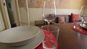 A dining table with a white plate, a clear wine glass, and a red placemat. - Italianway Easy - Melzo 12 - Vintage (Milan)