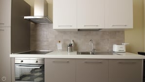 A modern kitchen with a double sink, stainless steel appliances, and beige cabinetry. - Italianway Easy - Melzo 12 - Vintage (Milan)