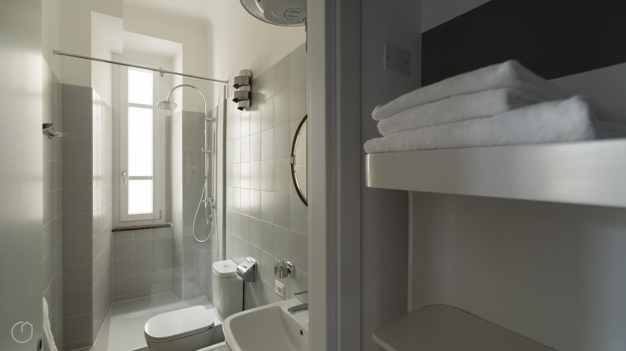 A modern bathroom with a glass-enclosed shower, a toilet, and a sink.