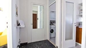 A laundry room with a washing machine, a mirror, and a shelf with a sign. - Mi-navp112a6 - Naviglio Pavese 112 (Milan)