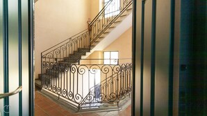 A staircase with ornate black railings and a tiled floor. - Italianway Easy - Pastrengo 11 A (Milan)