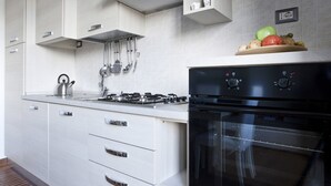 A modern kitchen with a gas stove, stainless steel appliances, and a built-in oven. - Italianway Easy - Piazza Firenze 4 (Milan)