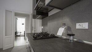 Et moderne køkken med gasblus, emfang og en bordplade med en flaske og et glas.