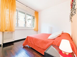 Ett sovrum med en säng, ett fönster och en lampa.