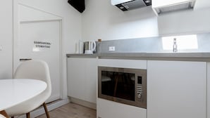 A compact kitchen with a built-in microwave, a coffee maker, and a kettle on the countertop. - Italianway Easy - Volta 21 (Milan)