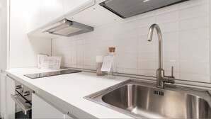 A modern kitchen with a stainless steel sink, a built-in oven, and a range hood. - Italianway Easy - Pasubio 12 (Novate Milanese)