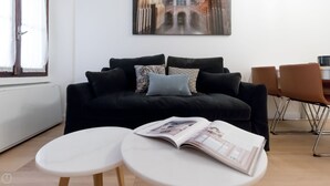 A modern living room with a black sofa, patterned cushions, and a magazine on a small table. - Mi-vige13a3 - Vigevano 13 (Milan)