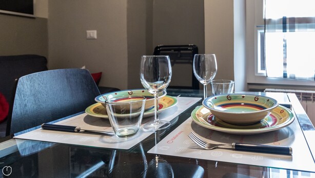 A dining table set with plates, bowls, wine glasses, and cutlery. - Italianway Easy - Paisiello 4 A (Milan)