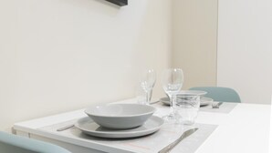 Une table à manger dressée avec un saladier, des assiettes, des verres et des couverts.