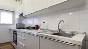 Une cuisine moderne équipée d’appareils électroménagers en acier inoxydable, d’un four encastré et d’un évier.