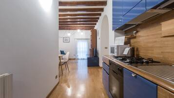 Una cocina con armarios de madera, estufa y microondas.