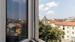 A view from a window overlooking a cityscape with buildings and a church. - Italianway Easy - Ampere 103 (Milan)