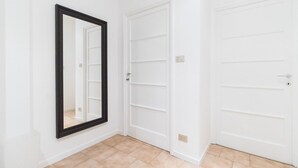 A room with a large mirror, two white doors, and a tiled floor. - Italianway Easy - Sacconi 2 A (Milan)