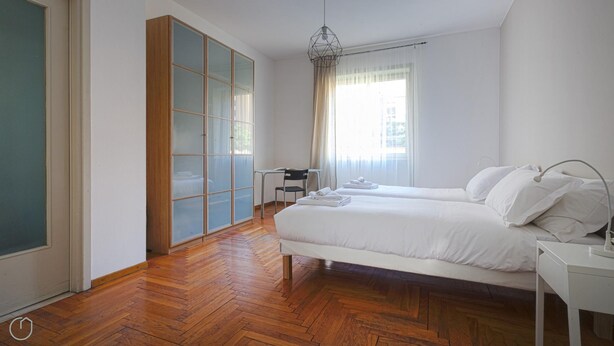 Un dormitorio con cama, escritorio y armario.