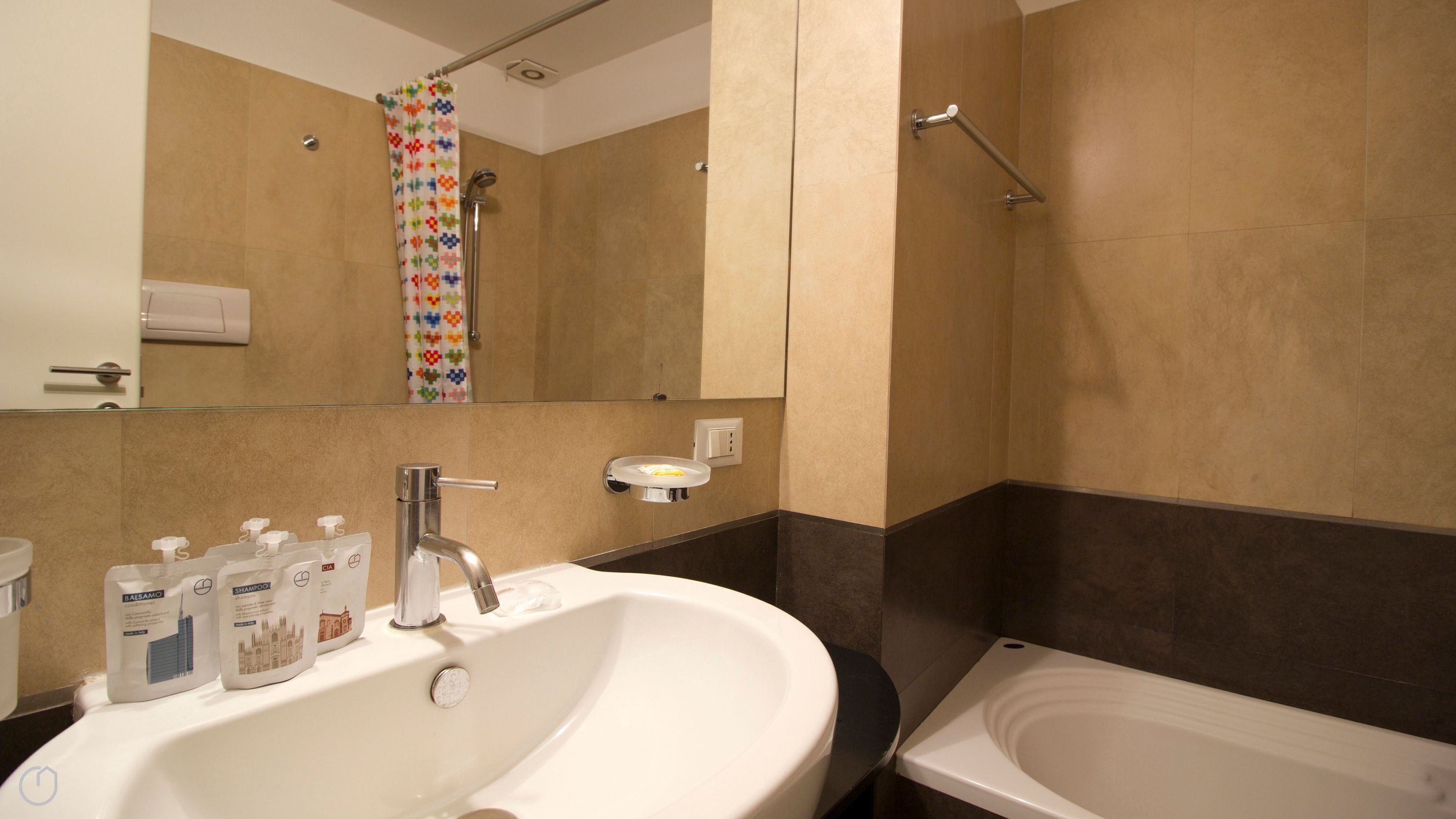 A bathroom with a sink, mirror, and bathtub.