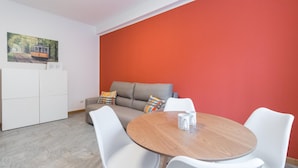 A modern living room with a grey sofa, white chairs, and a wooden table. - Italianway Easy - Piceno 23 A (Milan)