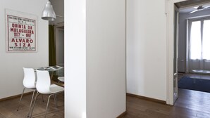 Un intérieur moderne avec une table en verre, des chaises blanches et un luminaire suspendu.