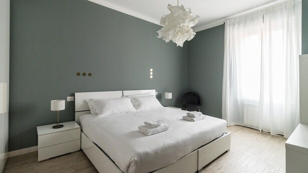 A modern bedroom with a large bed, bedside tables, and a unique chandelier. - Italianway Comfort - Buenos Aires 65 A (Milan)
