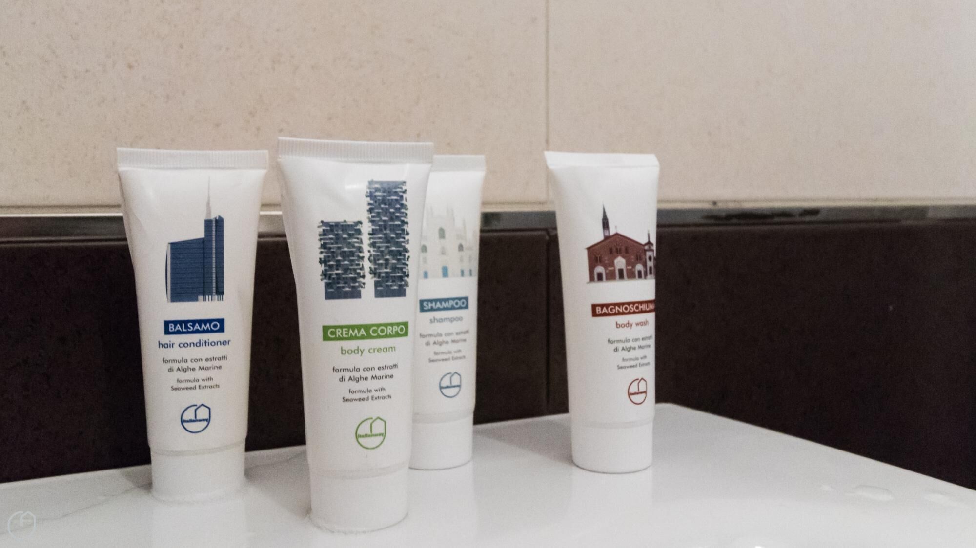 Kolme hygieniatuotetta valkoisella alustalla, taustalla beige seinä.