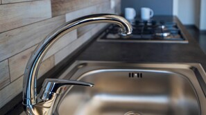 Een moderne keuken met een roestvrijstalen spoelbak en een gebogen kraan.