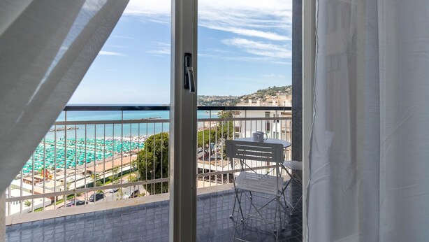 Un balcón con vista a la playa y al paisaje urbano.