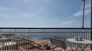 Un balcon avec vue sur une plage et la mer.