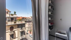 Een balkon met uitzicht op omliggende gebouwen en een straat.