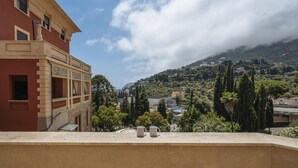 Un bâtiment doté d’un balcon donnant sur un paysage montagneux.