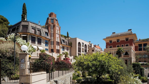 Un quartier résidentiel où se côtoient une architecture moderne et traditionnelle, avec notamment un bâtiment imposant doté d’une tour et un bâtiment plus petit avec un toit en pente.