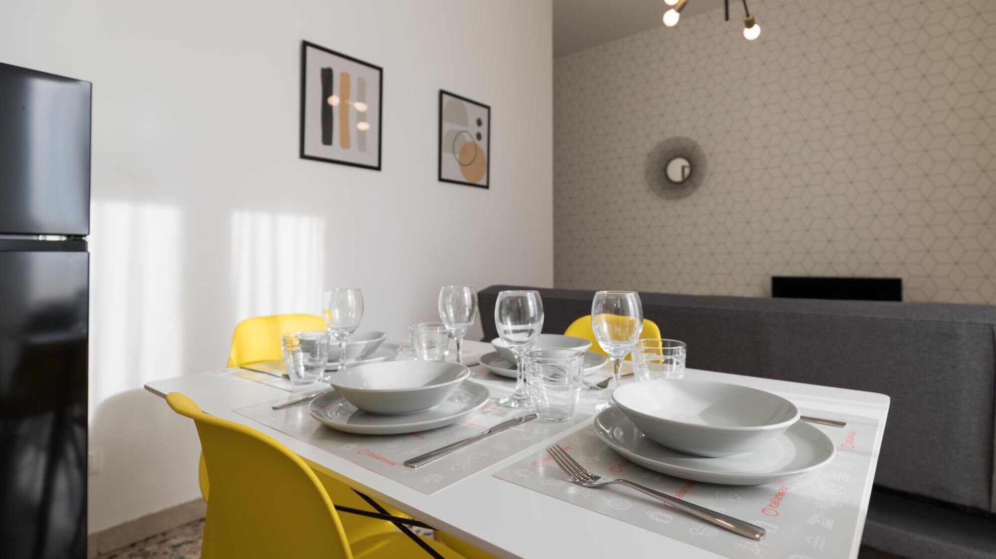A dining area with a table set for four, including plates, glasses, and cutlery.