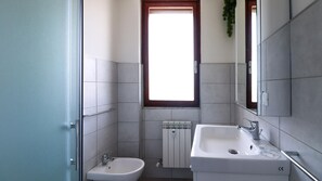 A small bathroom with a window, a bidet, and a sink. - Tubino 8 (Rapallo)