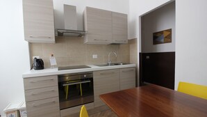 Una cucina moderna con forno integrato, elettrodomestici in acciaio inox e un tavolo da pranzo in legno.